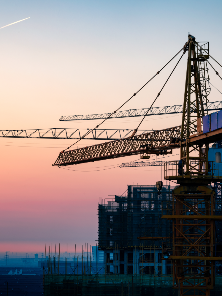 construction site featuring a tower crane at sunset